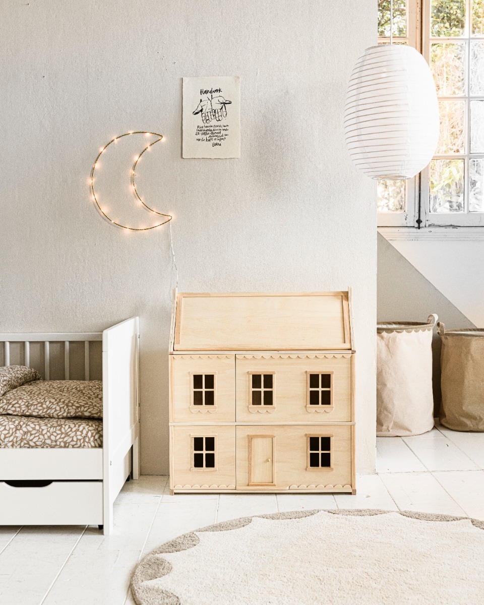 Maison de poupée en bois naturel avec façade classique, fenêtres et porte ouvrantes, au design épuré et intemporel.